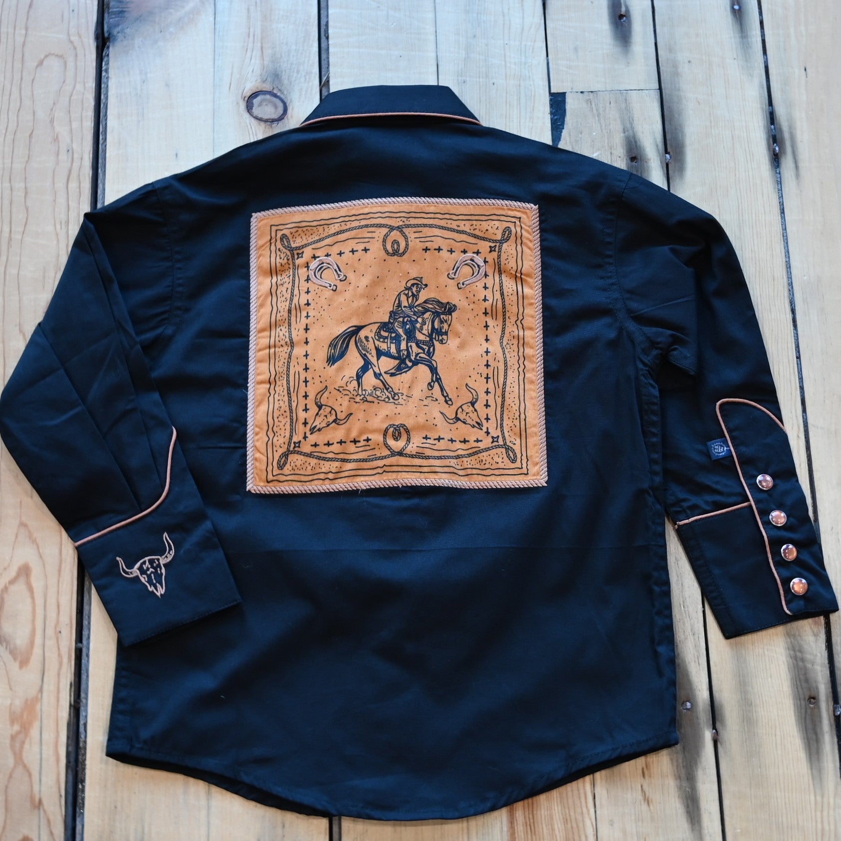 View of Rockmount Kids black western shirt with steer, horseshoe, and rope embroidery