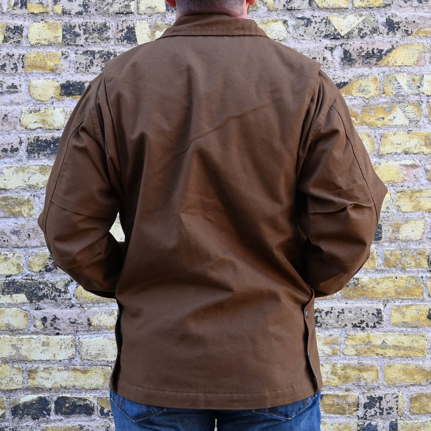 View of Schaefer tobacco-colored canvas ranch jacket with quilted liner, snap-out ride vents, and multiple utility pockets