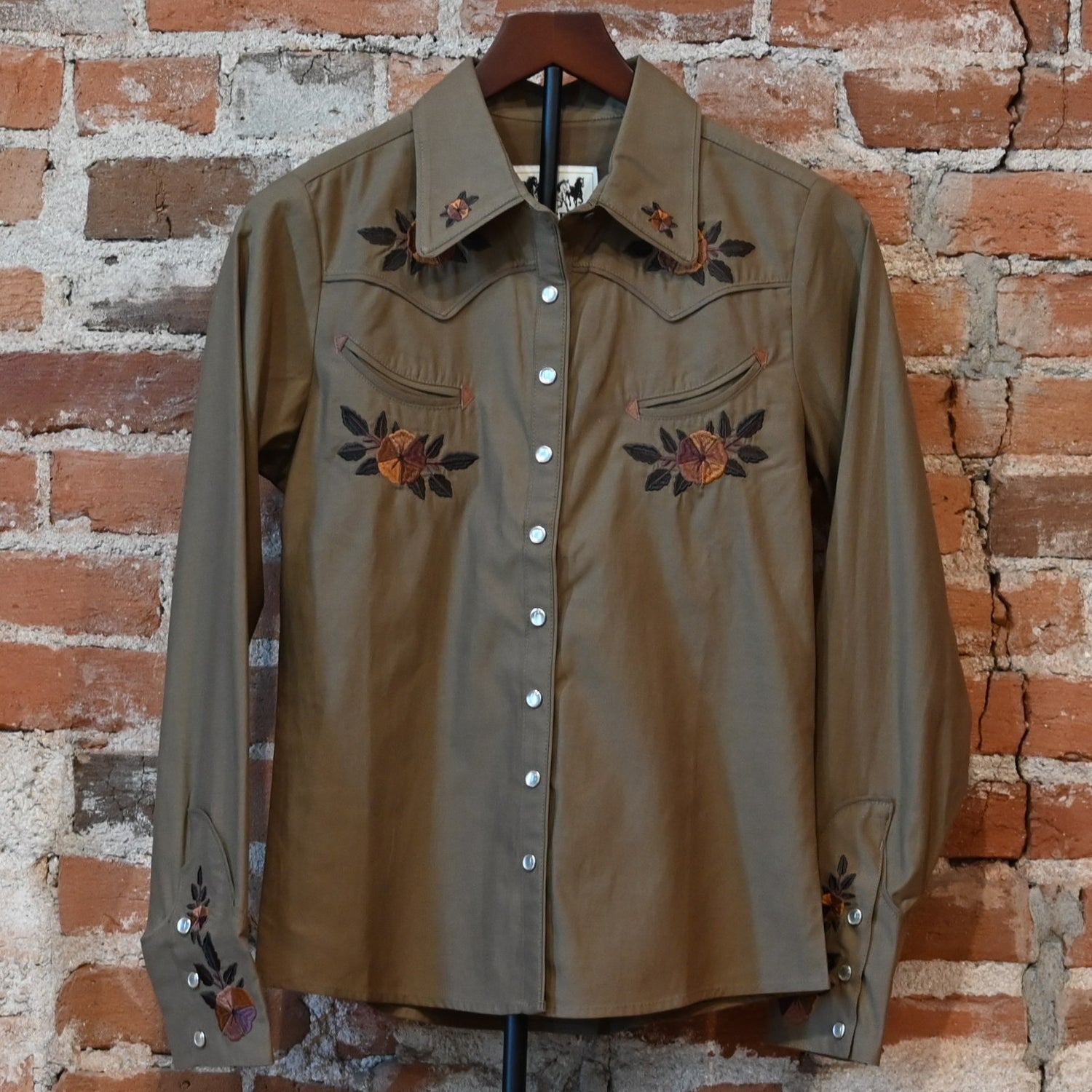 Schaefer Outfitter Ladies Embroidered Snap Shirt in chestnut with floral embroidery, leather-detailed pockets, and snap closures