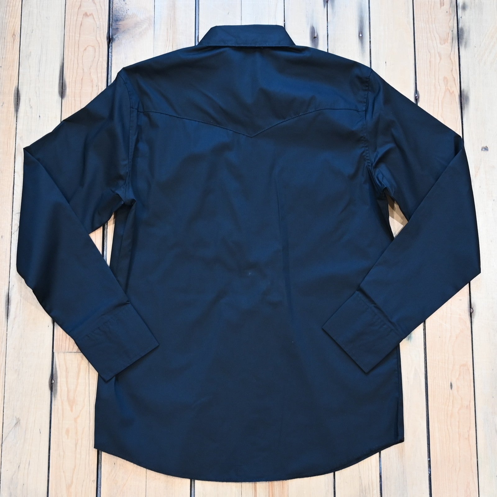 View of Wrangler men’s black Western snap shirt in broadcloth with yokes and flap pockets