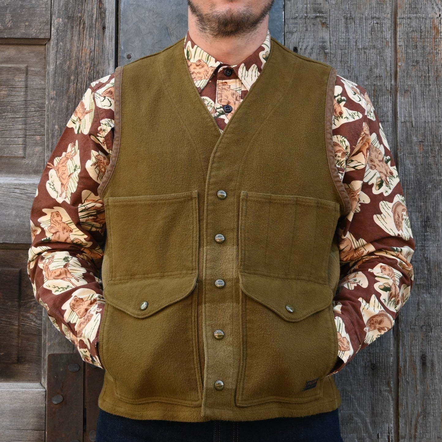 View of Filson Beartooth Cruiser Vest in Marsh Olive Blanket Stripe featuring snap-close front and reinforced pockets