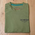 View of Sendero sage green Triceratops T-Shirt with cowboy roping a dinosaur graphic