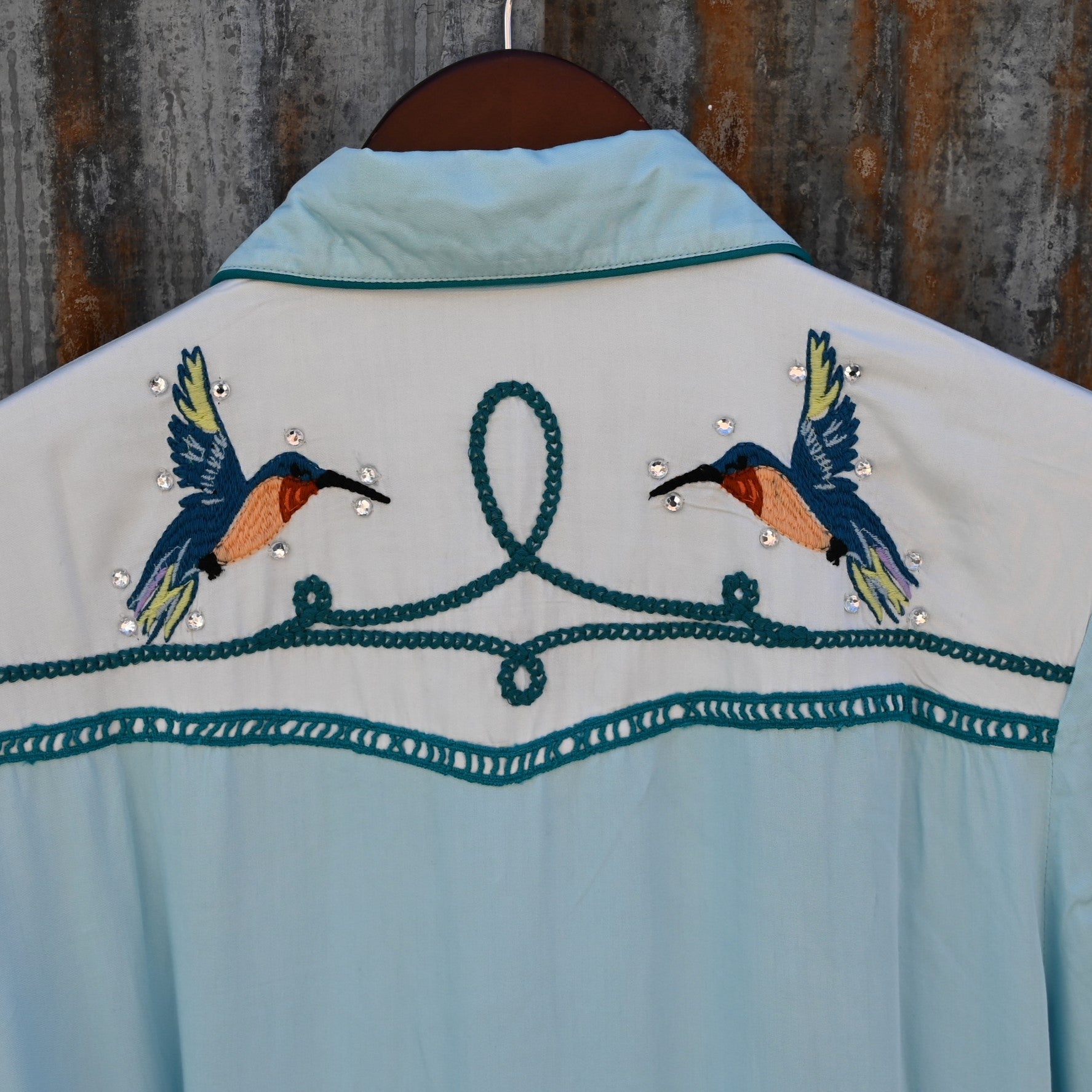 View of Double D Ranch Senoritas Rodeo Dress in Celestial Sky featuring embroidered floral print, pearl snap button closure, and drawstring waist