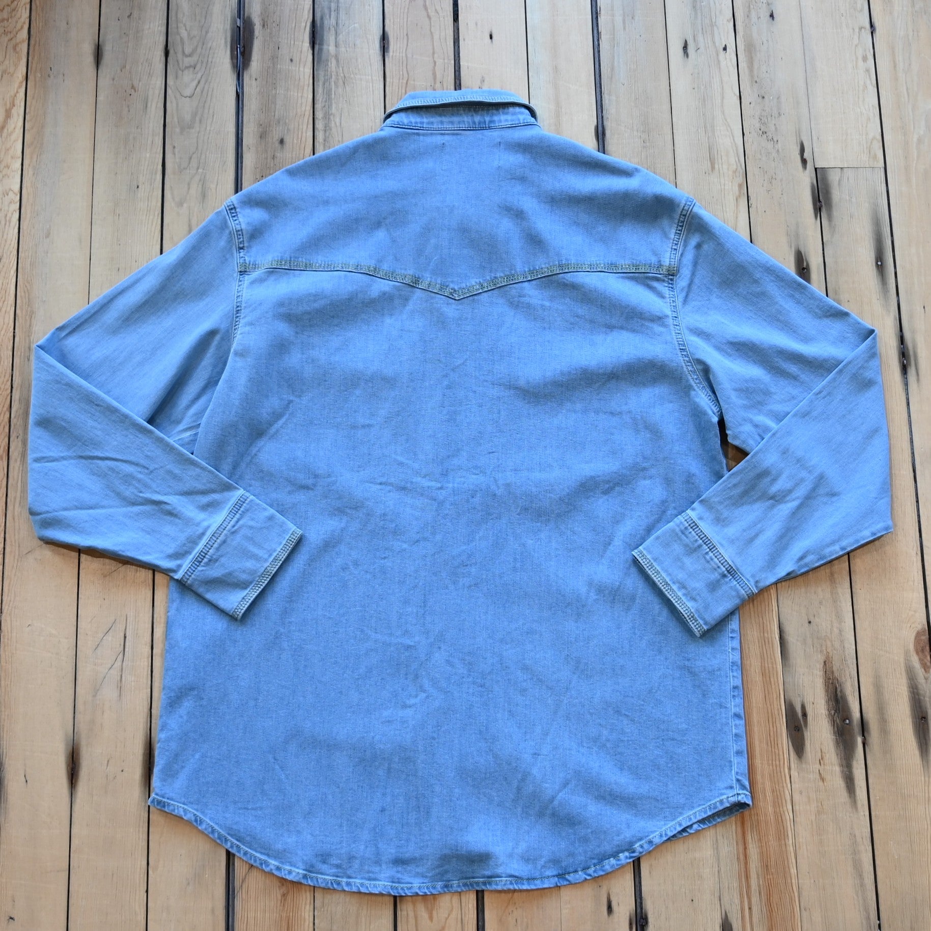 View of Schaefer denim snap shirt in dark indigo, gray, and light indigo with Western yokes and chest pockets