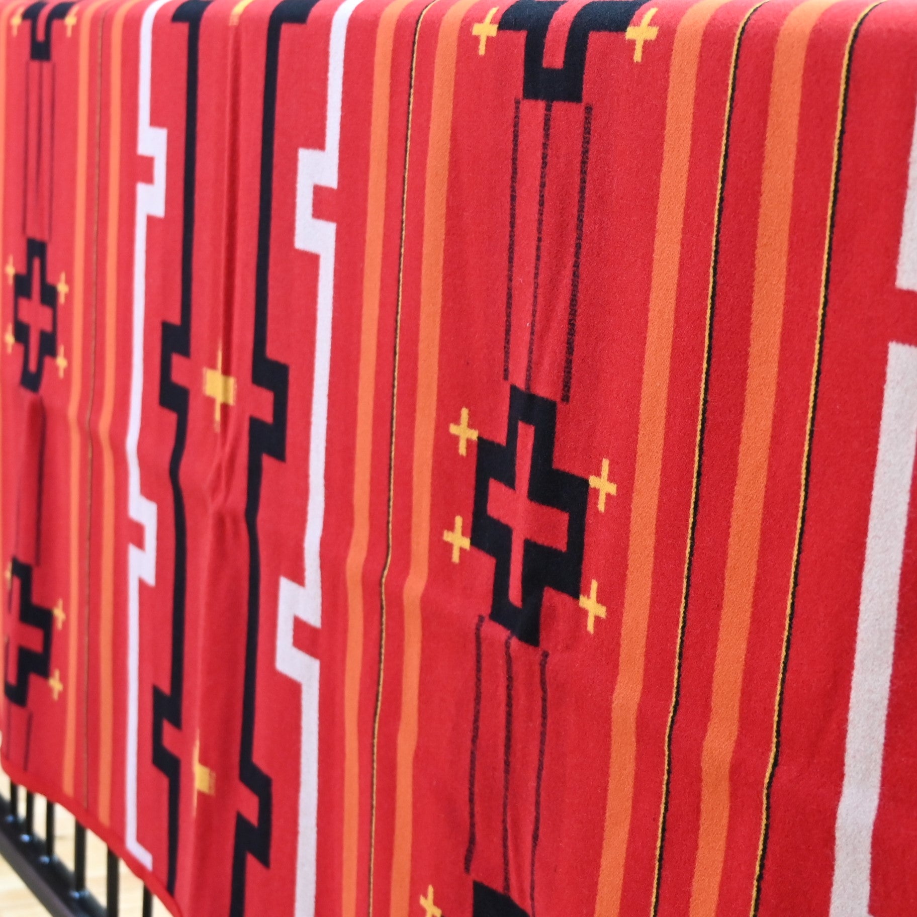 View of Red Pendleton robe blanket with geometric jacquard pattern and felt binding