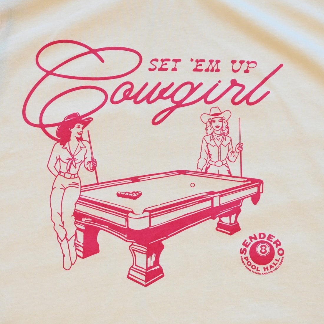 Ladies cream boxy tee by Sendero with two cowgirls playing pool and “Set ’Em Up Cowgirl” text