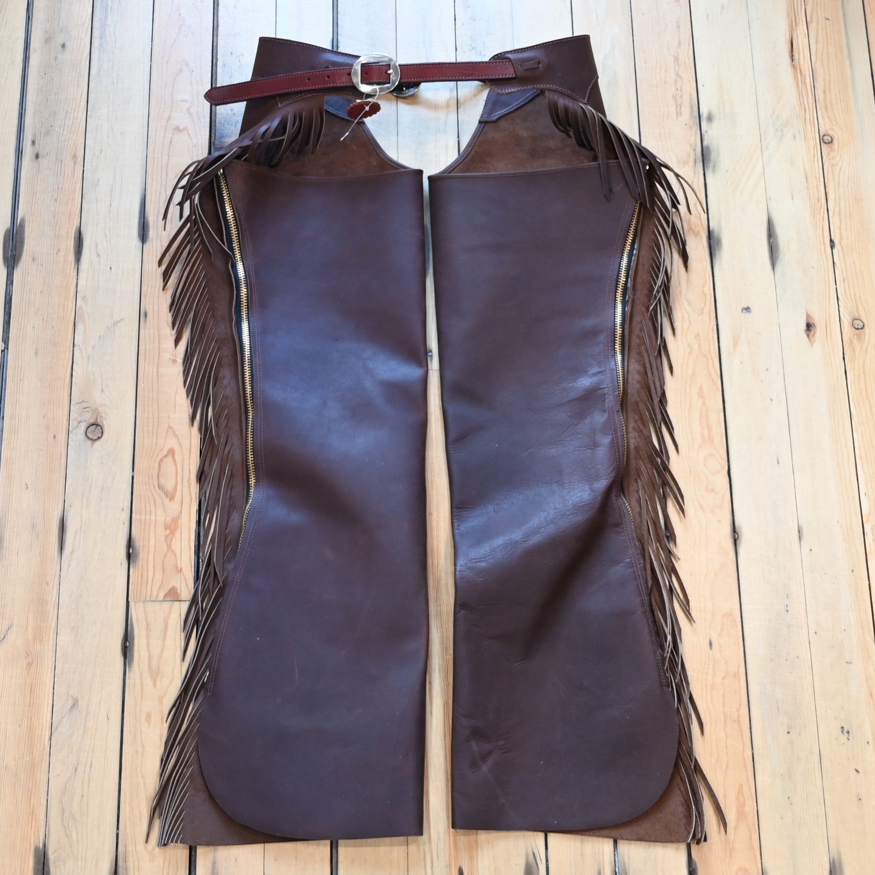 View of K Bar J Cowboy Basic Shotgun Chaps in Size Medium with fringe and buckle closures