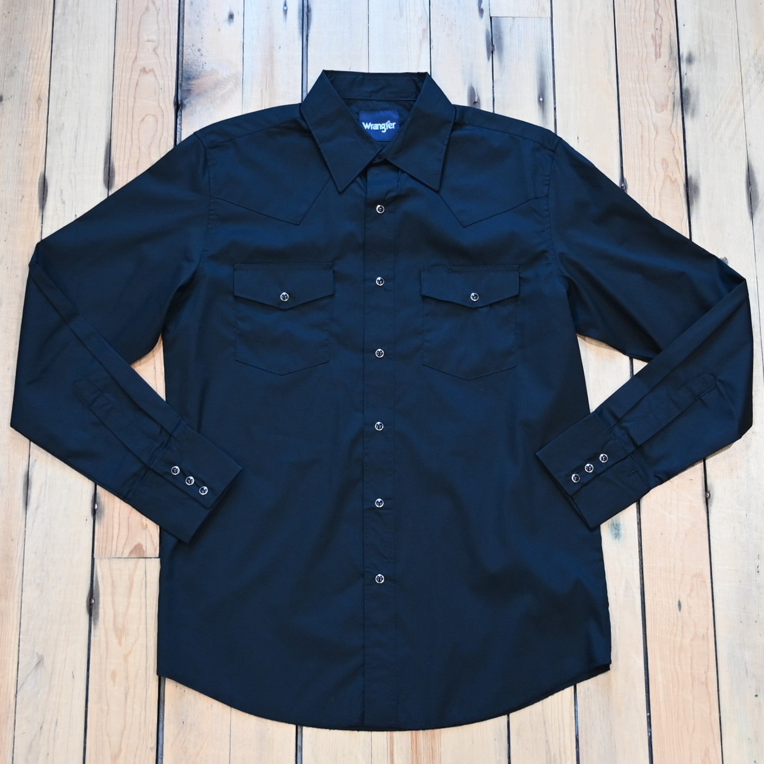 View of Wrangler men’s black Western snap shirt in broadcloth with yokes and flap pockets