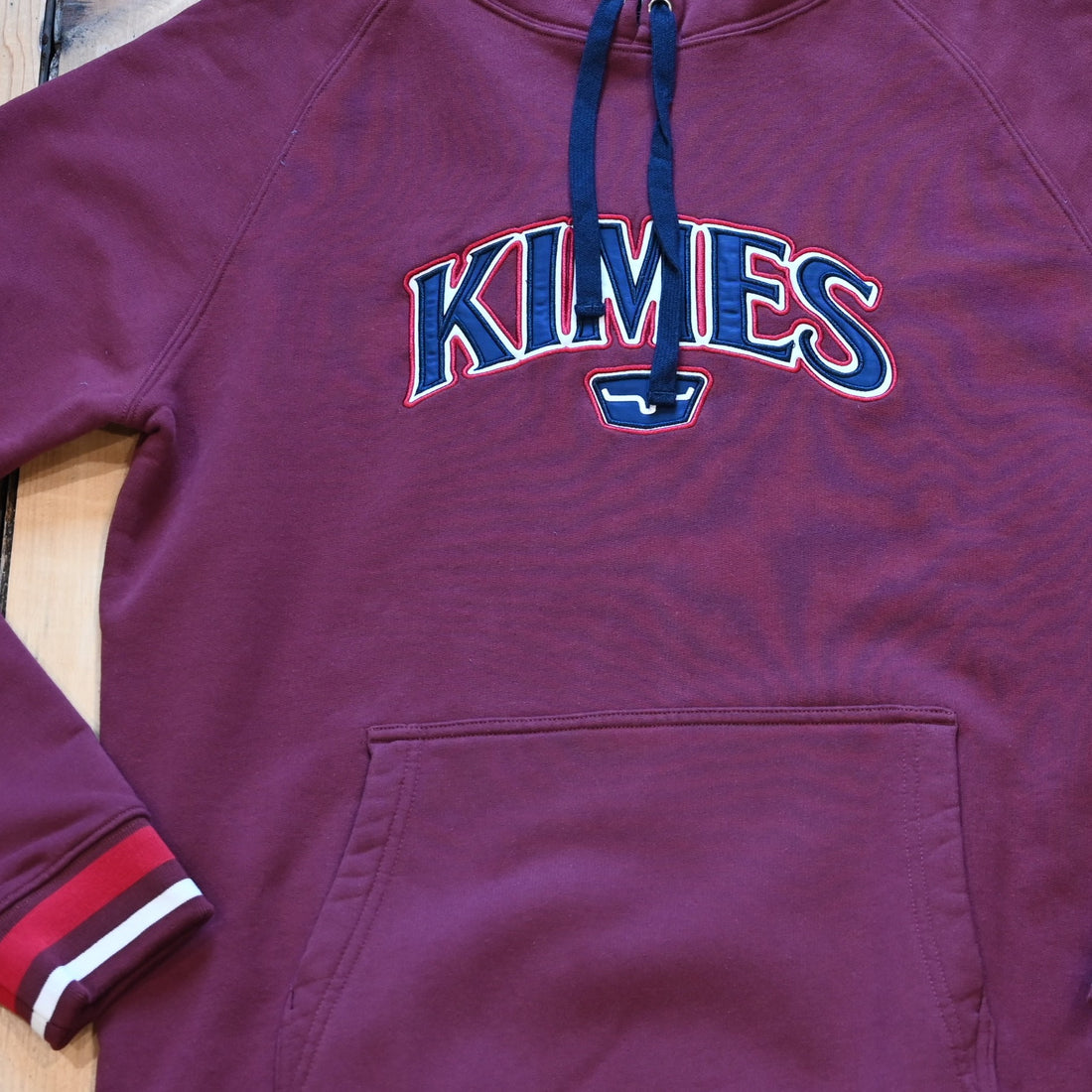 View of Kimes Ranch Kubo Sweatshirt in Burgundy, featuring a vibrant striped bottom and embroidered logo