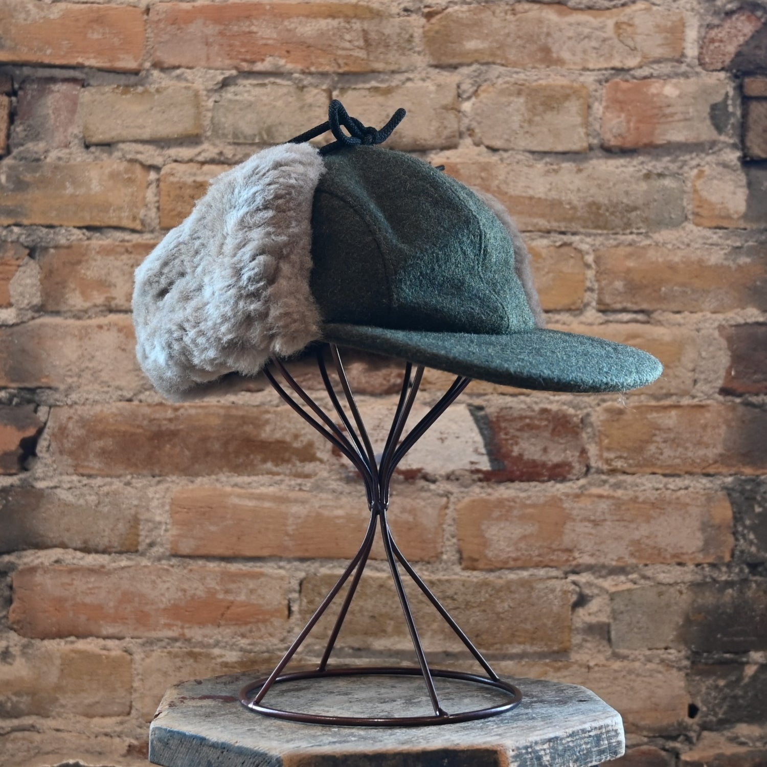 View of Filson Double Mackinaw Cap in Forest Green/Acorn and Burgundy/Dark Olive Plaid featuring shearling-lined earflaps and a 3" bill