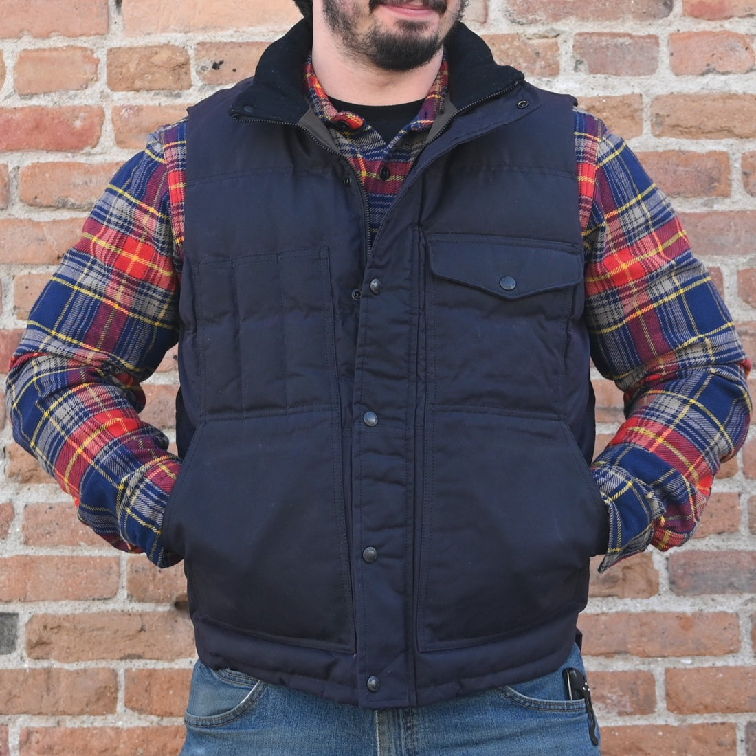 View of Filson Down Cruiser Vest in Dark Tan and Blue Coal featuring oil finish Cover Cloth and multiple pockets