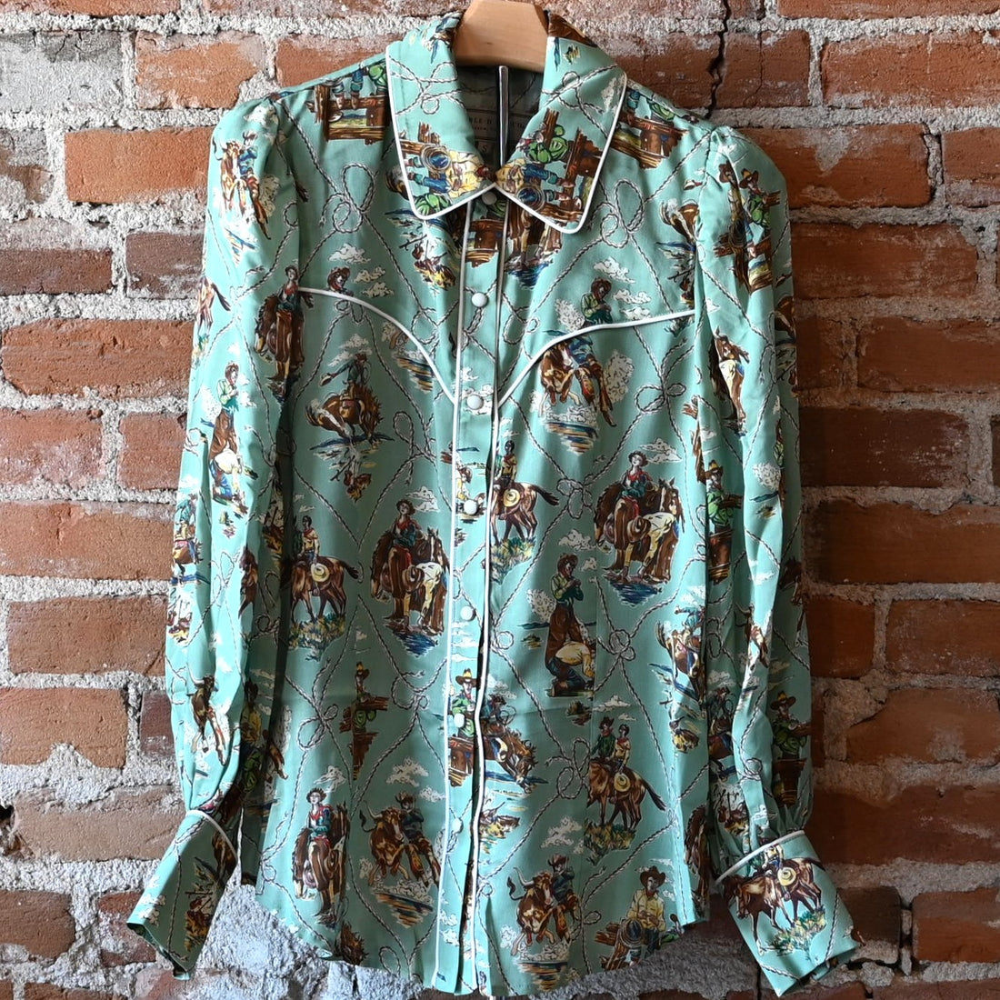 Ladies Romance & Rustlers Top by Double D Ranch with mint-green pulp-art print, pearl snaps, contrast piping, and full cuffed sleeves