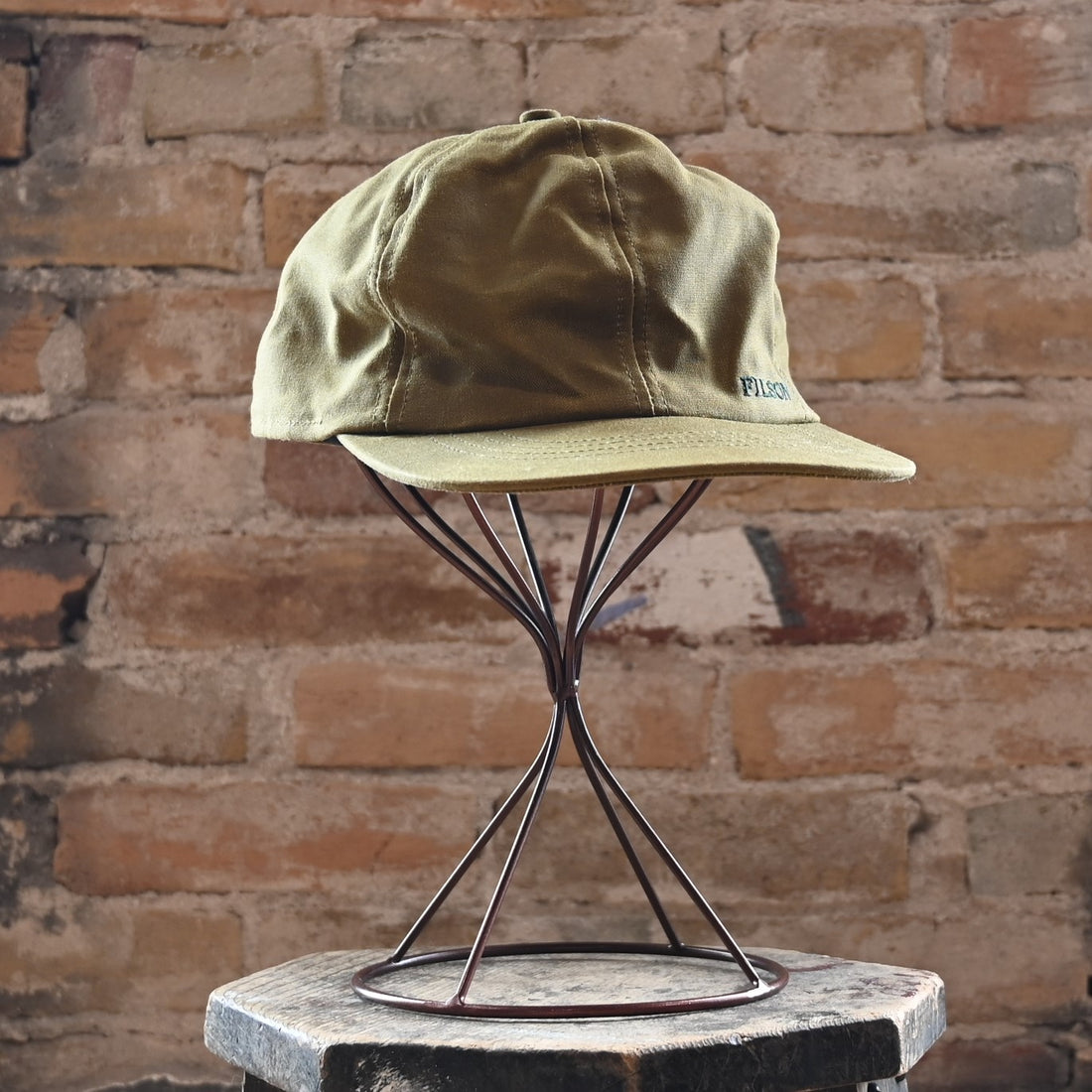 View of Filson Insulated Tin Cloth Cap in Dark Tan featuring wool ear/neck flap and 3" pre-curved bill
