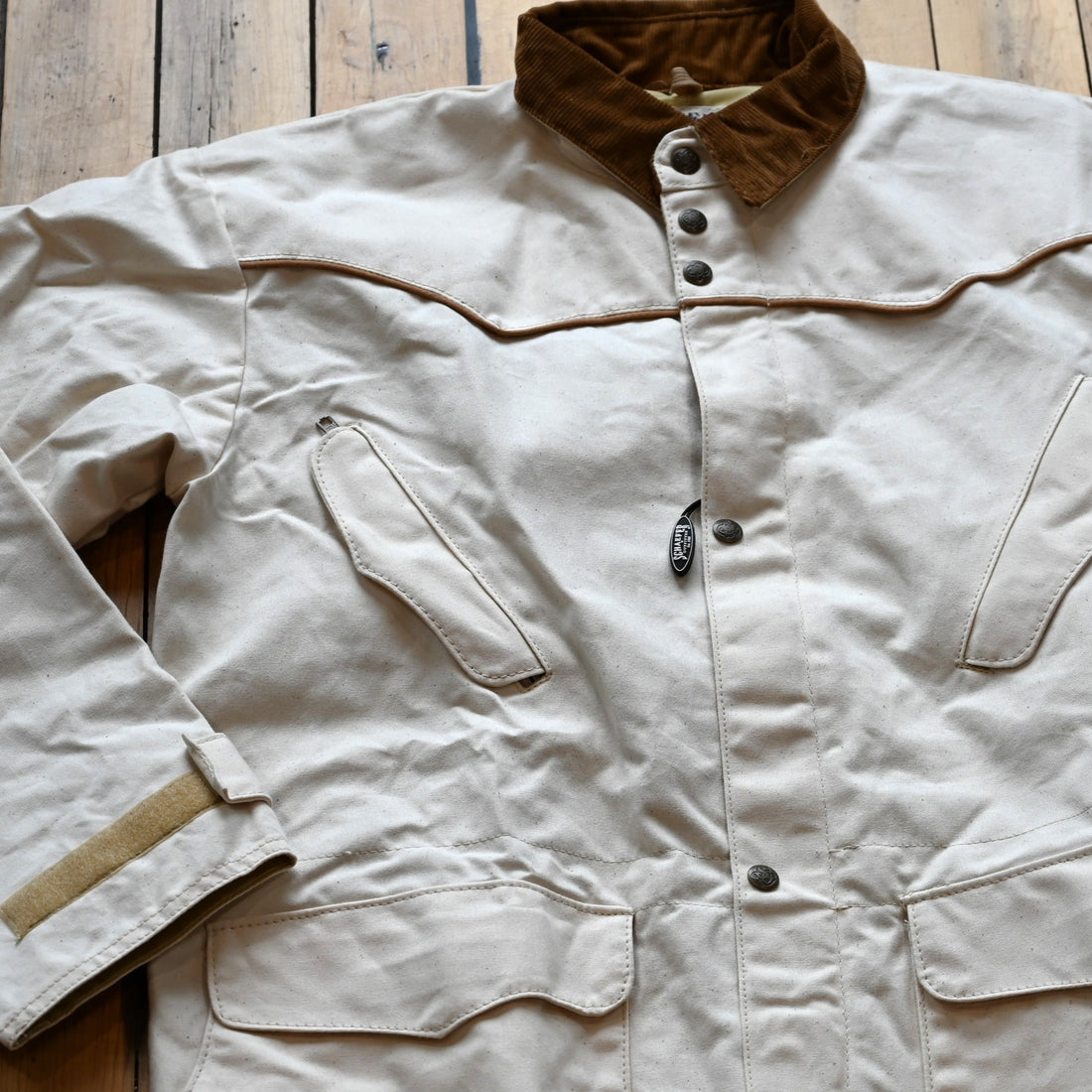 View of Natural canvas full-length duster with snap front, storm flap, and corduroy collar