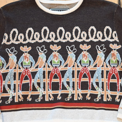 View of Long Tall Texan cropped sweater in bronco brown with embroidered cowboy characters, contrasting cuffs, and rope detail