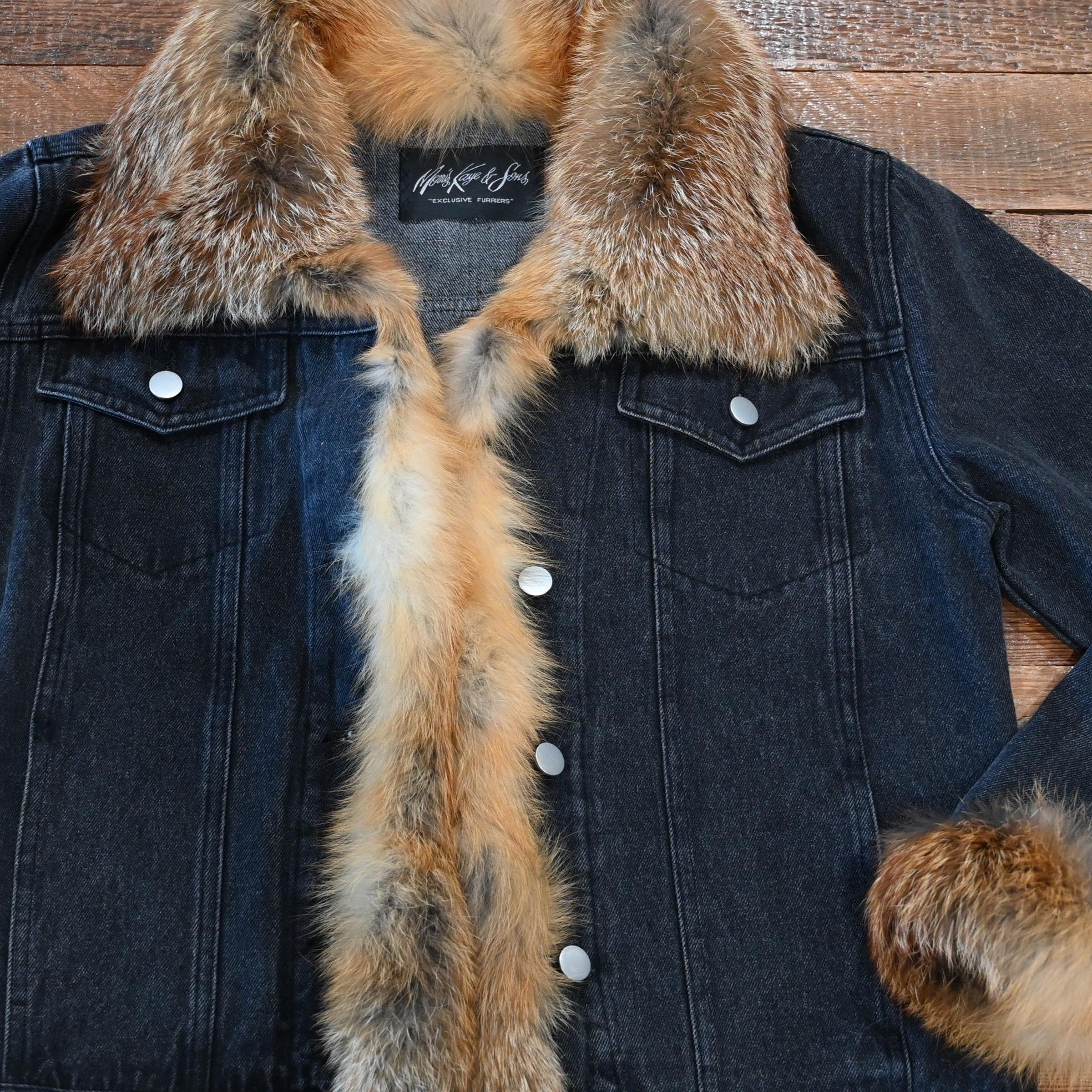 Black denim jacket with red fox fur trim on collar, cuffs, and front placket