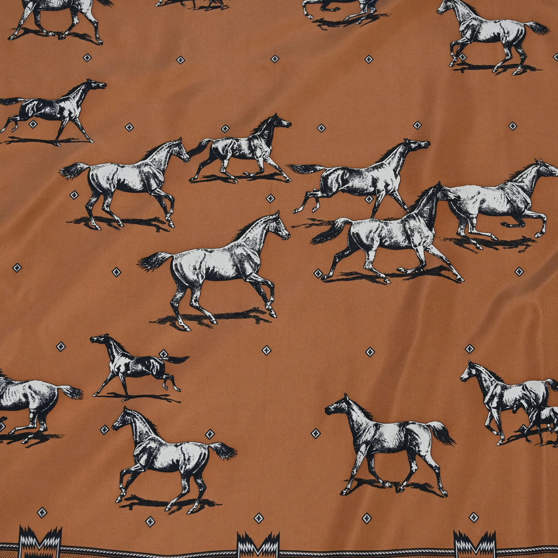 Square silk scarf in clay featuring a herd of horses print with hand-finished hem