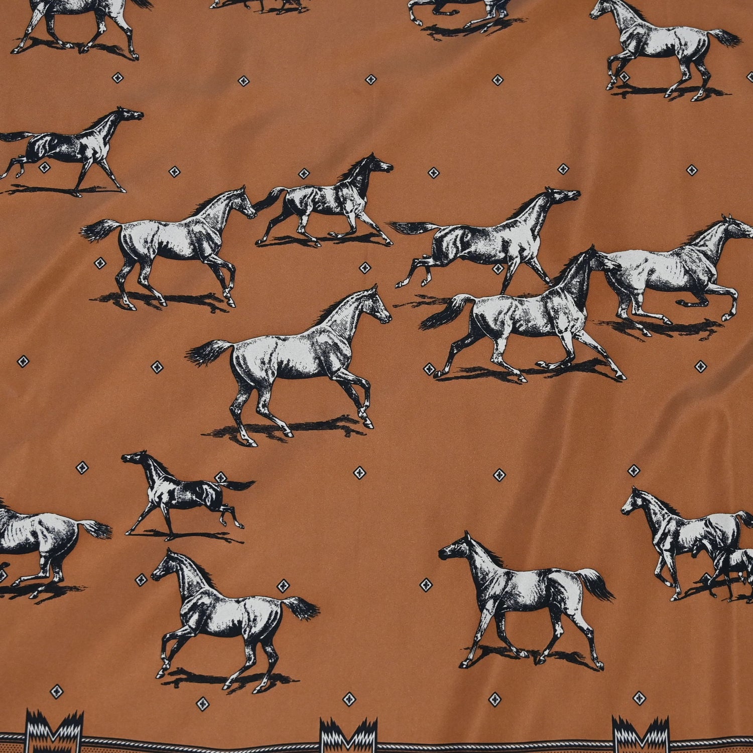 Square silk scarf in clay featuring a herd of horses print with hand-finished hem