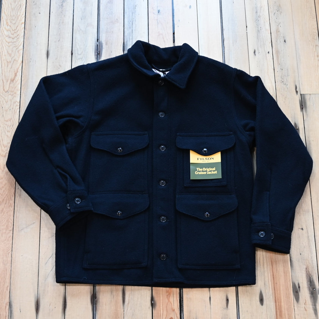 View of Filson Mackinaw Cruiser in Navy, Charcoal & Natural/Black Heritage Plaid featuring button-secure front closure, adjustable cuffs, and multiple pockets