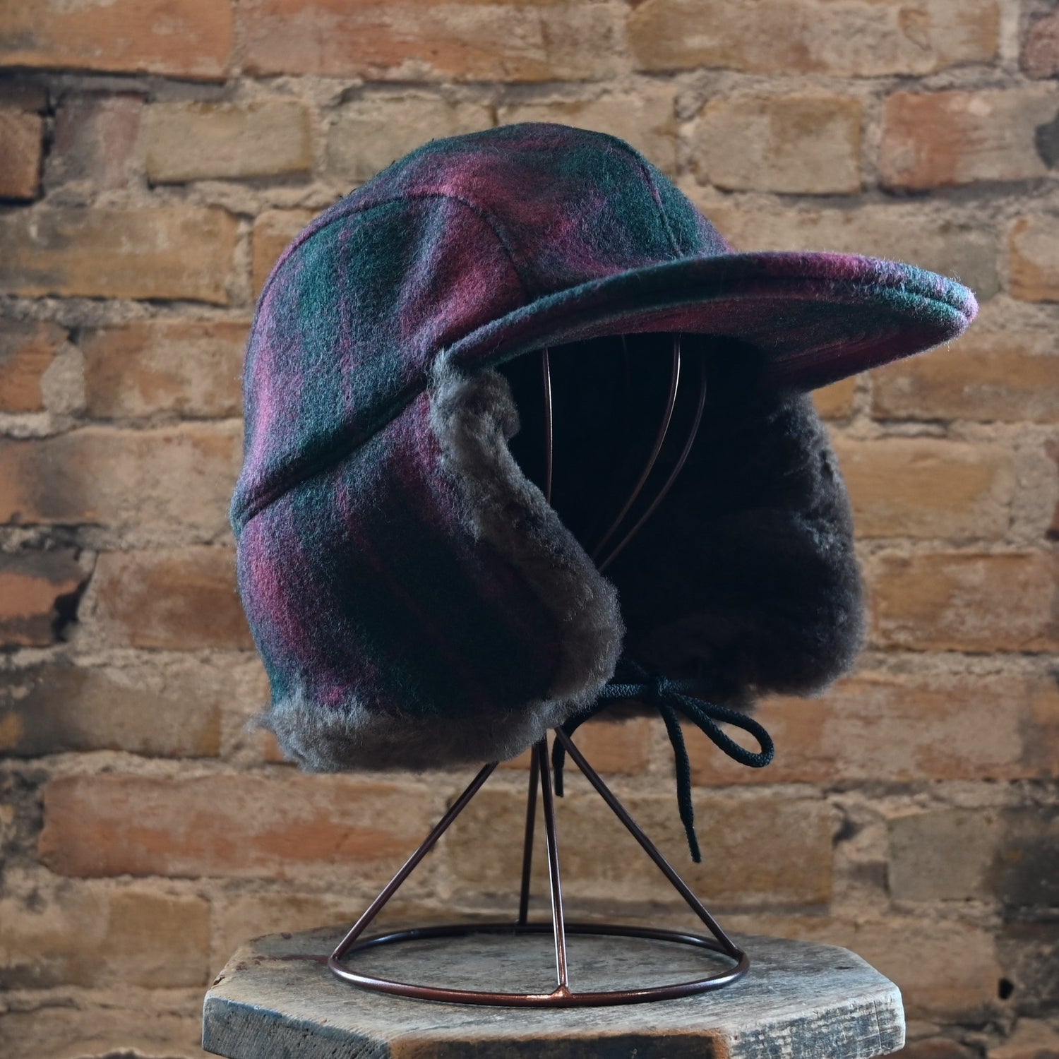 View of hat with flaps down in burgundy dark olive plaid