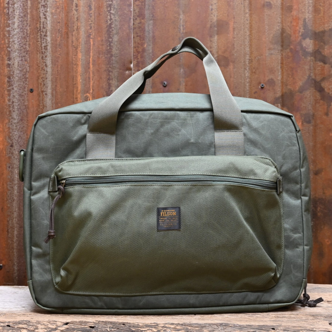 View of Filson Surveyor Pullman Pack in Service Green, showcasing its durable construction and spacious design