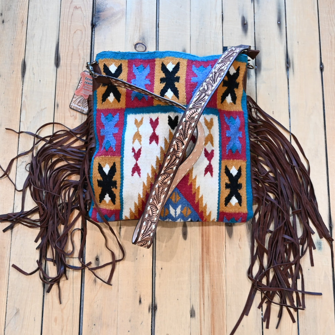 American Darling vintage saddle blanket conceal carry bag in burgundy, rust, blue, and brown with brown leather fringe on the sides