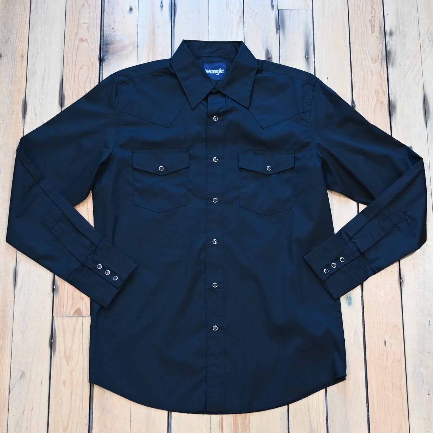 View of Wrangler men’s black Western snap shirt in broadcloth with yokes and flap pockets