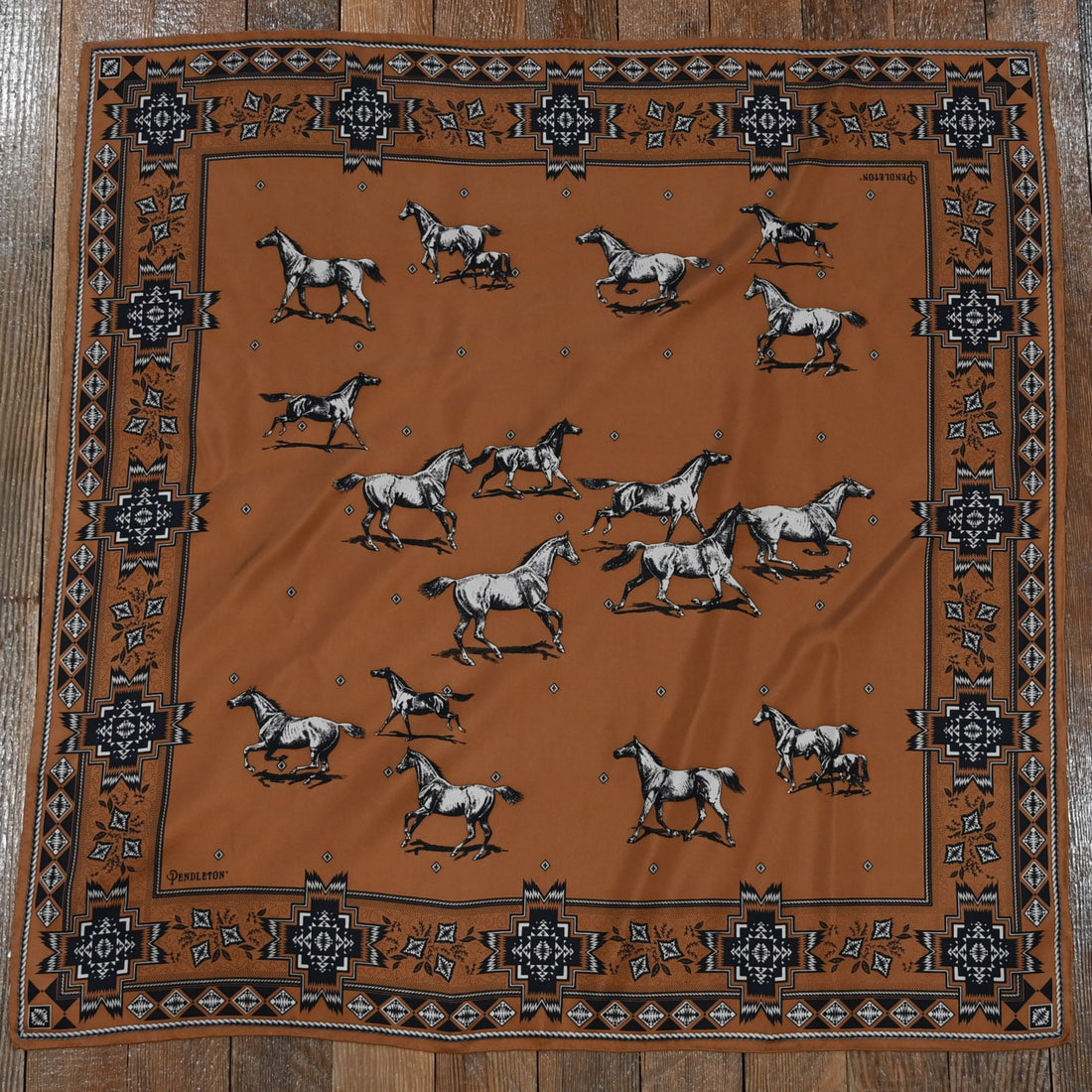 Square silk scarf in clay featuring a herd of horses print with hand-finished hem